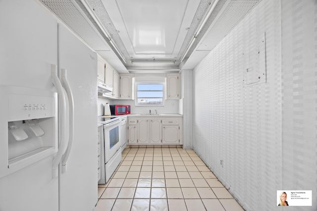 137 Golden Isles Dr Unit 806, Hallandale Beach, FL 33009 - kitchen with white appliances, under cabinet range hood, white cabinetry, and light countertops