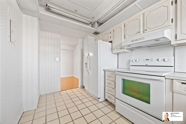 137 Golden Isles Dr Unit 806, Hallandale Beach, FL 33009 - kitchen featuring white appliances, under cabinet range hood, light countertops, and light tile patterned flooring
