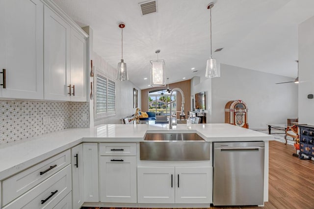 kitchen with visible vents, dishwasher, a sink, a peninsula, and open floor plan