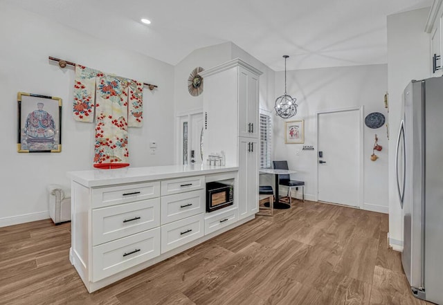 interior space with an inviting chandelier, baseboards, freestanding refrigerator, and wood finished floors
