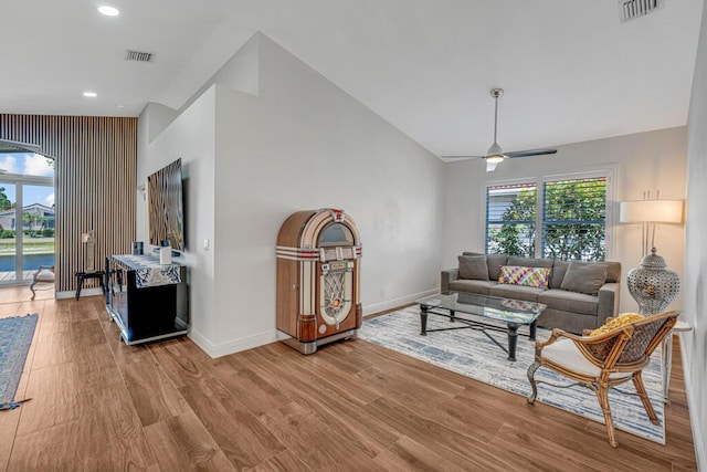 living area with baseboards, ceiling fan, wood finished floors, and visible vents