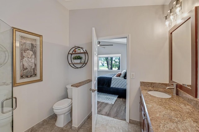 bathroom featuring a ceiling fan, vanity, baseboards, toilet, and ensuite bath
