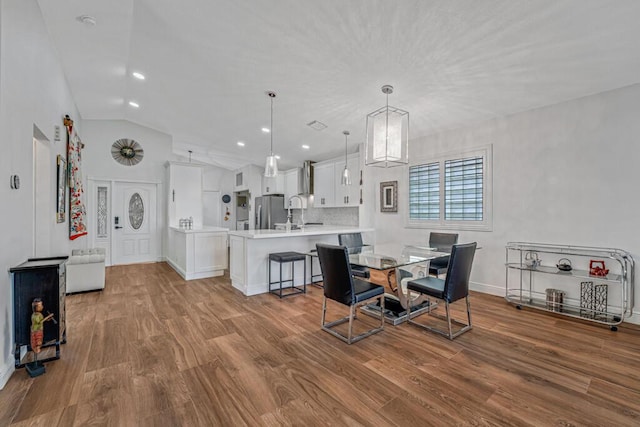 dining area featuring baseboards, recessed lighting, lofted ceiling, and wood finished floors
