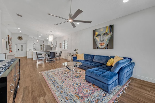 living room with a ceiling fan, visible vents, wood finished floors, and recessed lighting