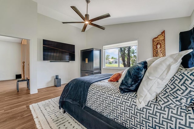 bedroom with baseboards, a ceiling fan, wood finished floors, and vaulted ceiling