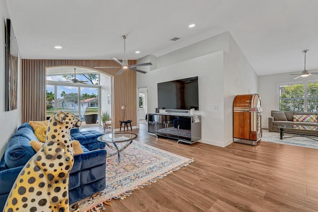 living room with vaulted ceiling, baseboards, a ceiling fan, and wood finished floors