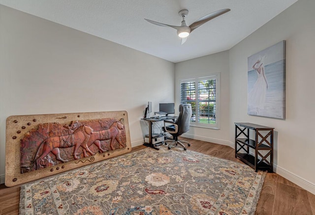 office with baseboards, a ceiling fan, and wood finished floors