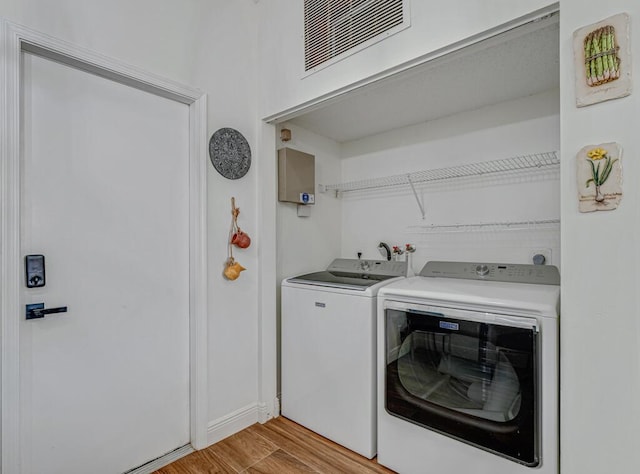 laundry room featuring light wood-style floors, visible vents, laundry area, and washer and clothes dryer