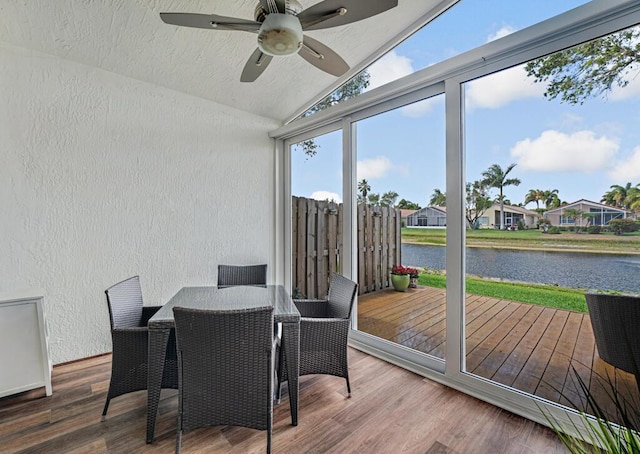 sunroom featuring a water view