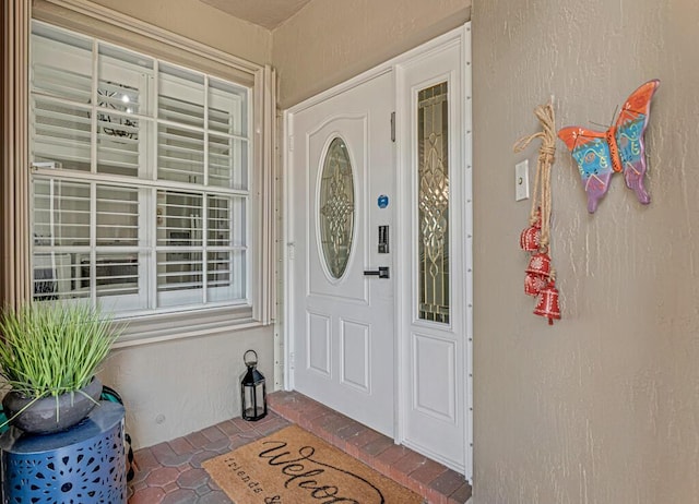 view of exterior entry featuring stucco siding and a porch