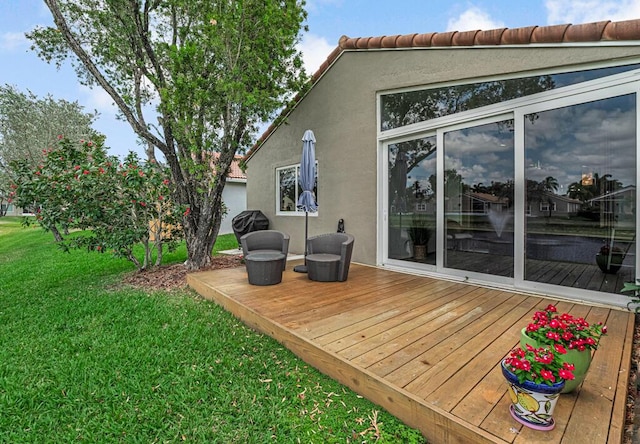 wooden terrace featuring a lawn