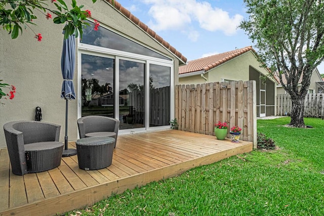 wooden deck featuring a lawn and fence