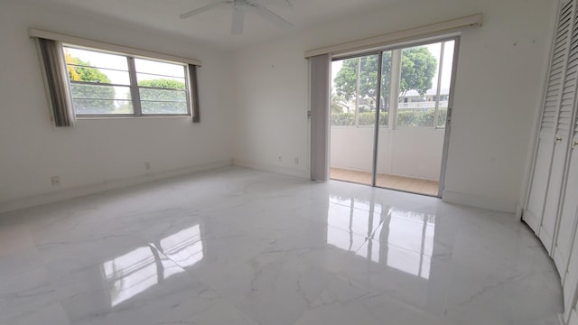 unfurnished bedroom with multiple windows, light marble finish flooring, baseboards, and access to exterior