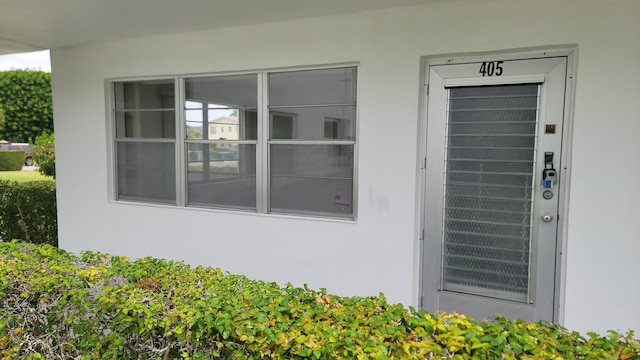 doorway to property featuring stucco siding
