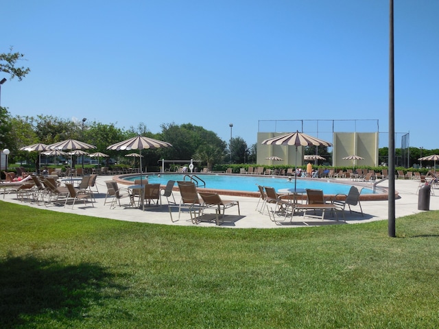 community pool with a lawn and a patio