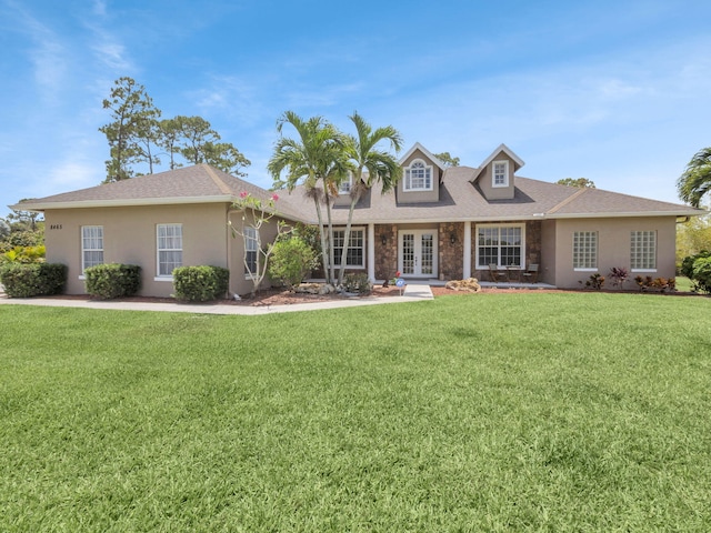 8465 Mandarin Blvd, Loxahatchee, FL 33470 - cape cod-style house featuring a front lawn, stucco siding, french doors, and stone siding