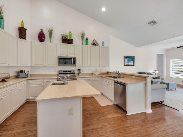 8465 Mandarin Blvd, Loxahatchee, FL 33470 - kitchen with visible vents, a peninsula, a sink, appliances with stainless steel finishes, and vaulted ceiling