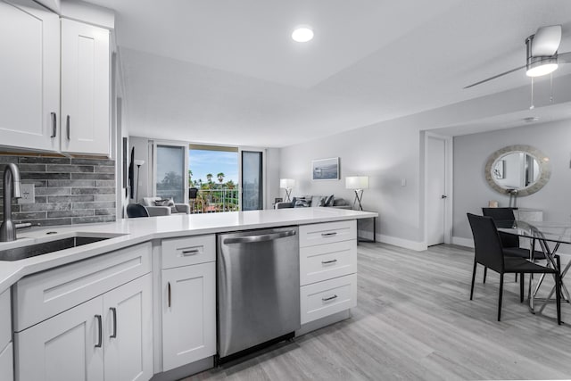kitchen featuring a peninsula, open floor plan, tasteful backsplash, a sink, and dishwasher