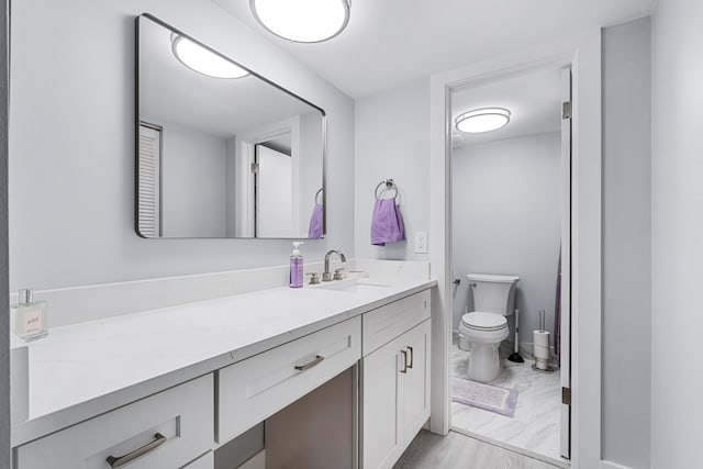 bathroom with vanity, toilet, and marble finish floor