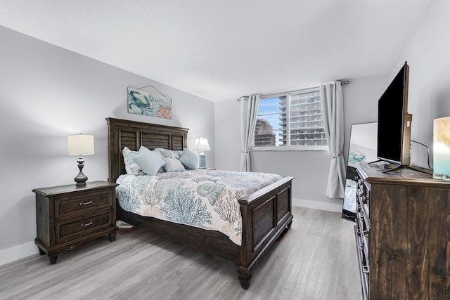 bedroom with baseboards and light wood finished floors