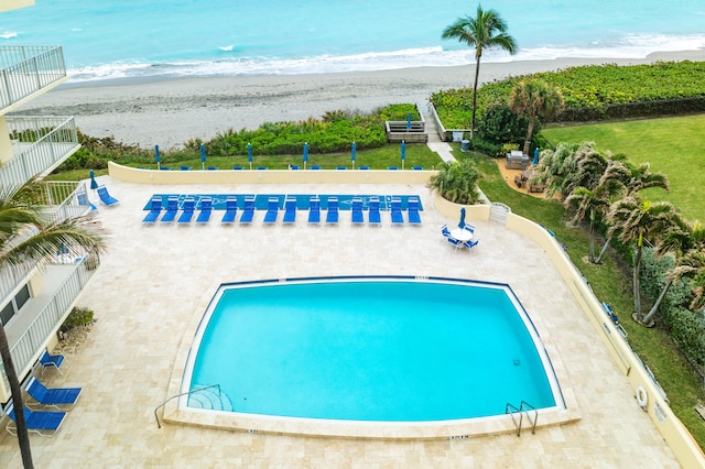 view of pool featuring a water view and a view of the beach