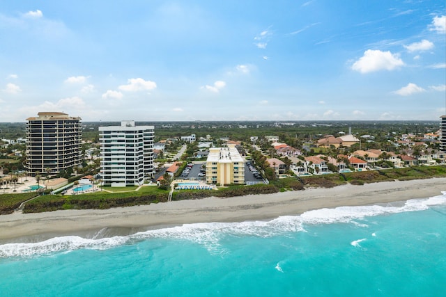 birds eye view of property with a water view and a beach view