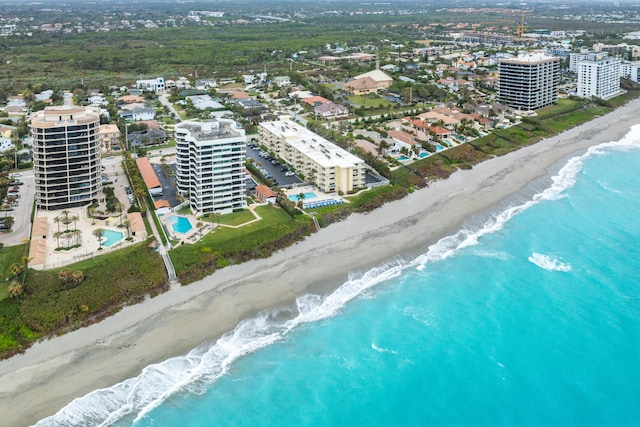 birds eye view of property with a water view and a beach view