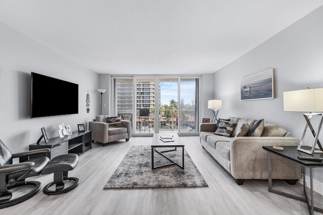 living room featuring floor to ceiling windows and wood finished floors