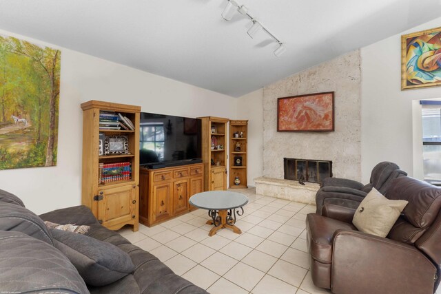 living area featuring track lighting, a high end fireplace, light tile patterned flooring, and vaulted ceiling