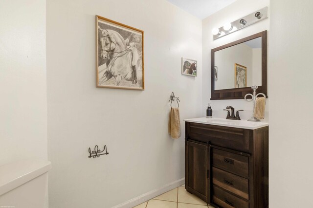 bathroom with vanity, baseboards, tile patterned floors, and toilet
