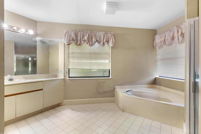full bathroom featuring tile patterned floors, vanity, a garden tub, and a wealth of natural light