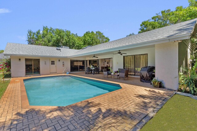outdoor pool featuring ceiling fan, a grill, and a patio area