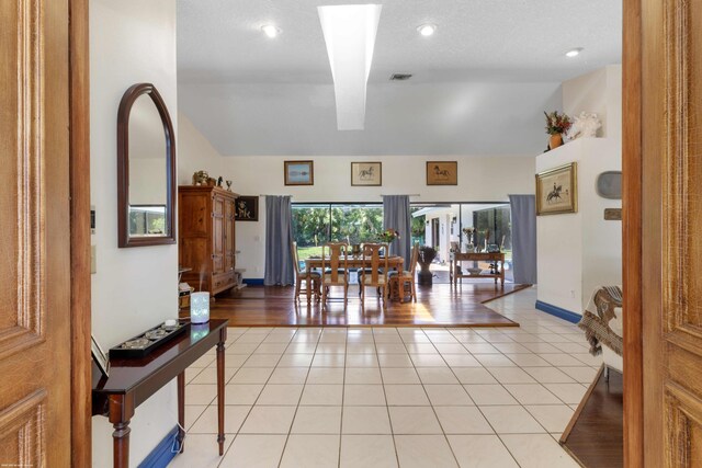 dining space with recessed lighting, visible vents, light tile patterned floors, and vaulted ceiling