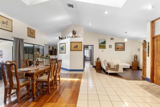 dining area featuring visible vents, baseboards, light wood finished floors, lofted ceiling with skylight, and recessed lighting
