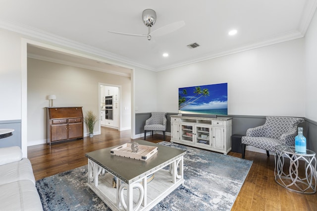 living area featuring baseboards, visible vents, ornamental molding, and wood finished floors