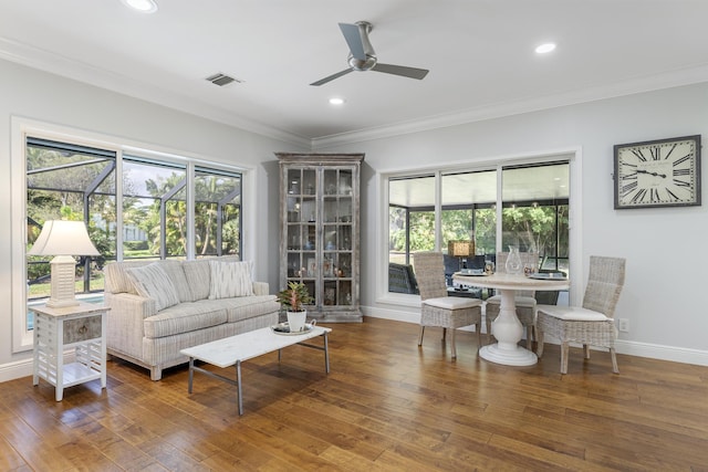 living room featuring crown molding, a ceiling fan, wood finished floors, and a healthy amount of sunlight