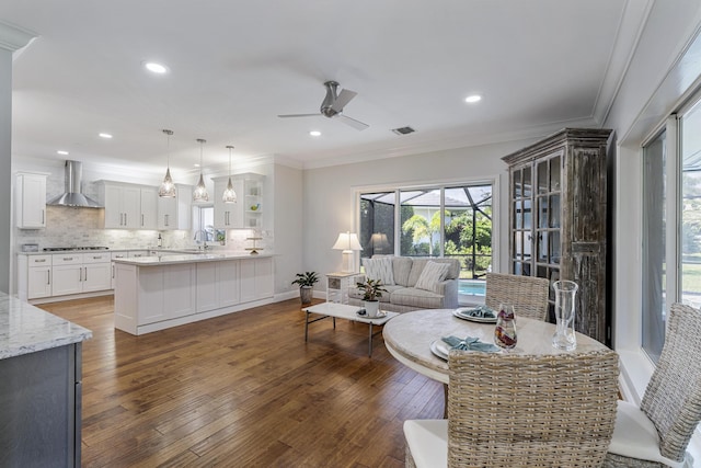 living area featuring crown molding, visible vents, recessed lighting, hardwood / wood-style flooring, and a ceiling fan