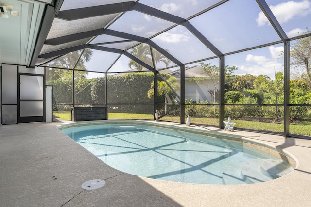 outdoor pool featuring a patio and glass enclosure