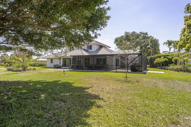 back of house featuring a yard, a lanai, and stucco siding