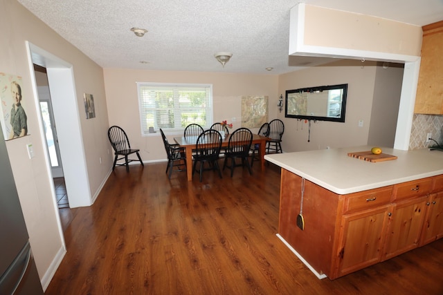 7175 NW 82nd Ct, Okeechobee, FL 34972 - kitchen with light countertops, a textured ceiling, brown cabinets, and dark wood-style floors