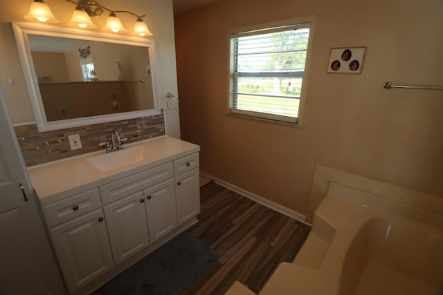 7175 NW 82nd Ct, Okeechobee, FL 34972 - full bathroom featuring wood finished floors, a bathtub, baseboards, decorative backsplash, and vanity