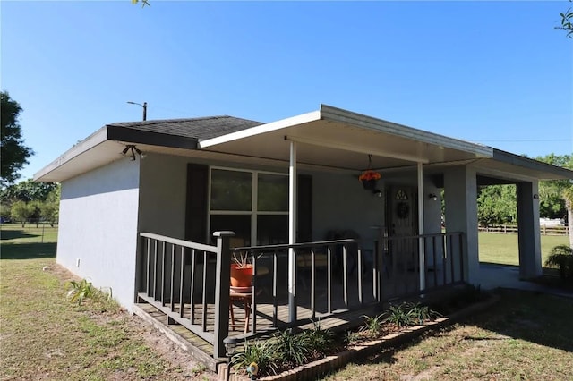 7175 NW 82nd Ct, Okeechobee, FL 34972 - back of property with a shingled roof, stucco siding, and a lawn