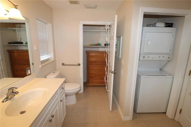 7175 NW 82nd Ct, Okeechobee, FL 34972 - bathroom featuring tile patterned flooring, stacked washer and clothes dryer, toilet, and vanity