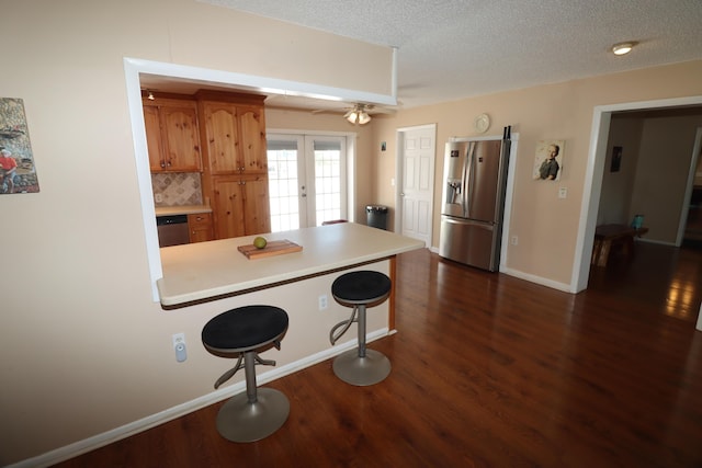 7175 NW 82nd Ct, Okeechobee, FL 34972 - kitchen with a textured ceiling, dark wood finished floors, a peninsula, light countertops, and appliances with stainless steel finishes