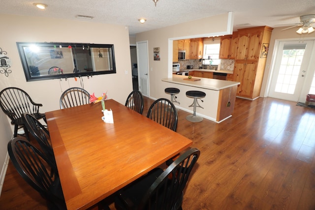 7175 NW 82nd Ct, Okeechobee, FL 34972 - dining space featuring a ceiling fan, dark wood finished floors, visible vents, and a textured ceiling