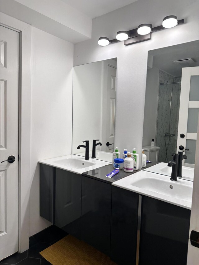 bathroom featuring a sink, walk in shower, and double vanity