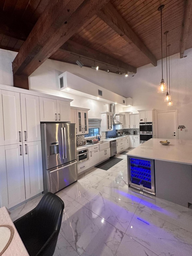 kitchen with tasteful backsplash, wooden ceiling, beamed ceiling, stainless steel appliances, and white cabinetry