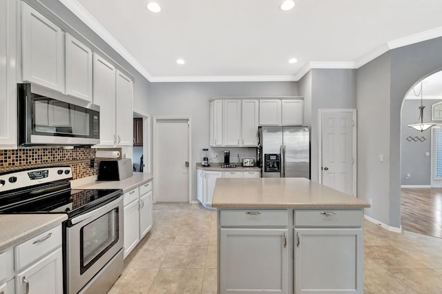 kitchen with crown molding, light countertops, tasteful backsplash, and stainless steel appliances