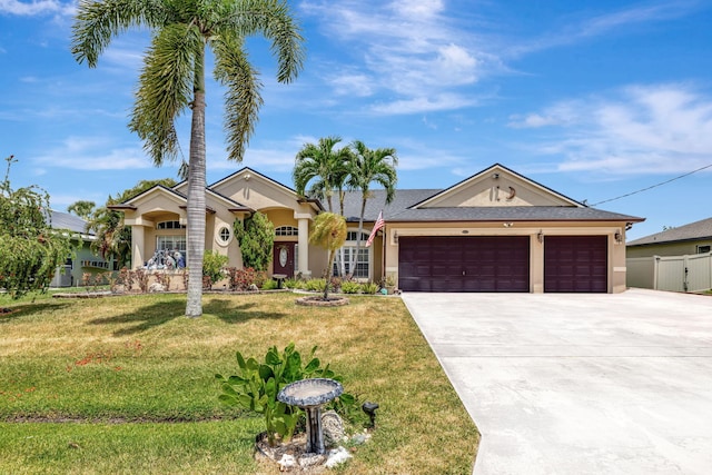 view of front of property with a front yard, fence, concrete driveway, an attached garage, and stucco siding