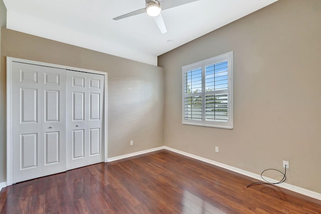unfurnished bedroom featuring a ceiling fan, baseboards, wood finished floors, and a closet